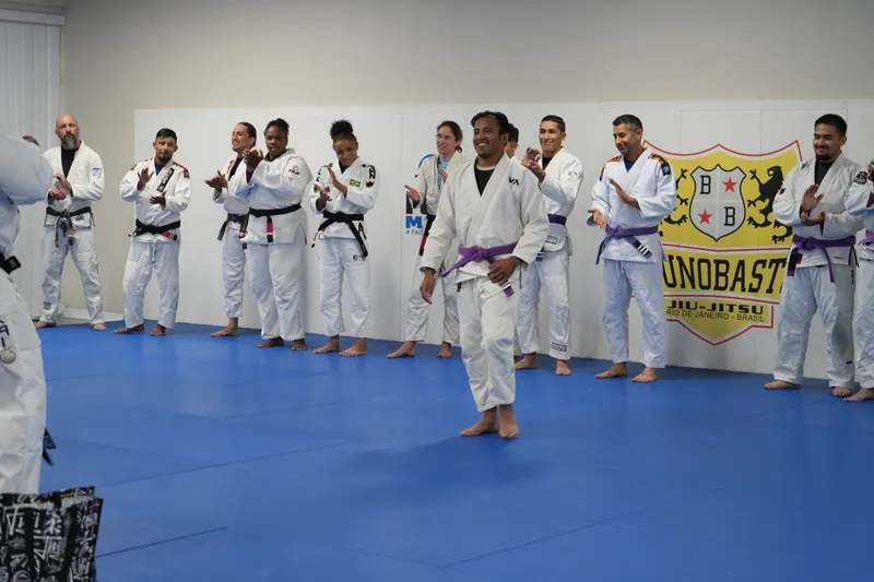 Bastos BJJ Midland full team on the mats — belt ceremony and class photo with Bruno Bastos banner