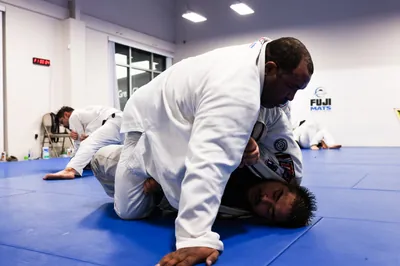 Adults Jiu-Jitsu training — ground technique on blue mats at Bastos BJJ Midland